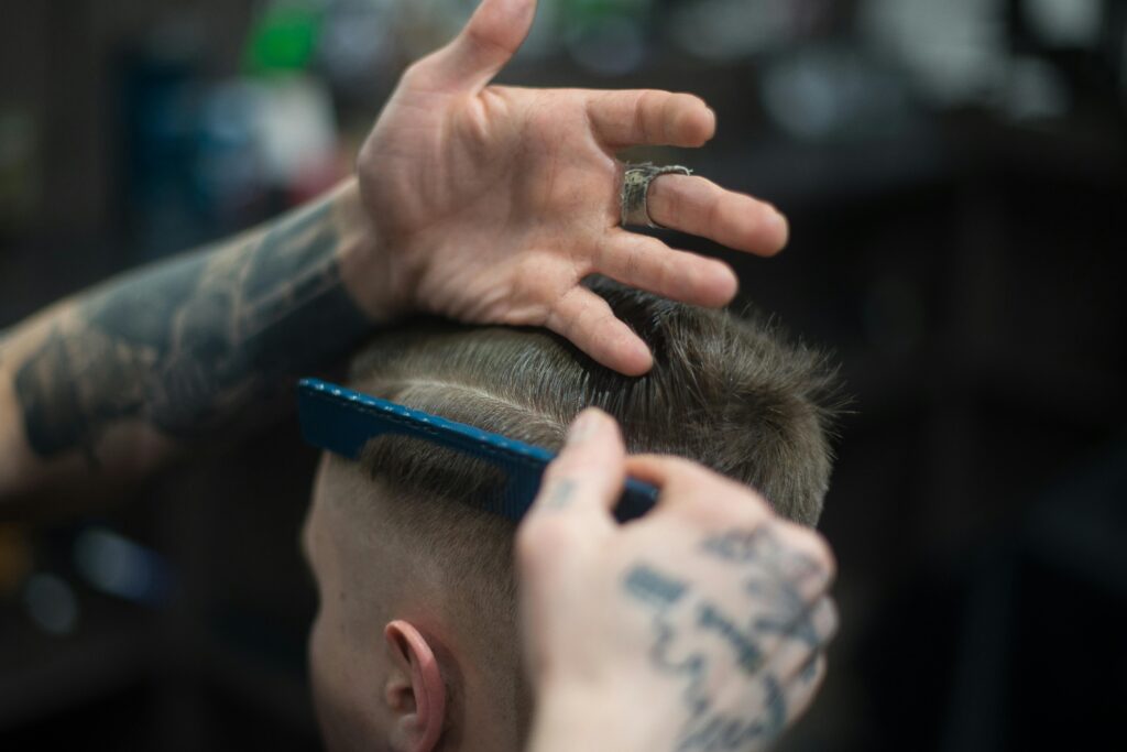 pexels photo 1570807 1570807 Close-up of a tattooed barber giving a stylish haircut indoors, highlighting modern grooming techniques.