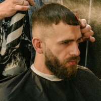 Strona główna A bearded man getting a fresh haircut at a stylish barber shop.